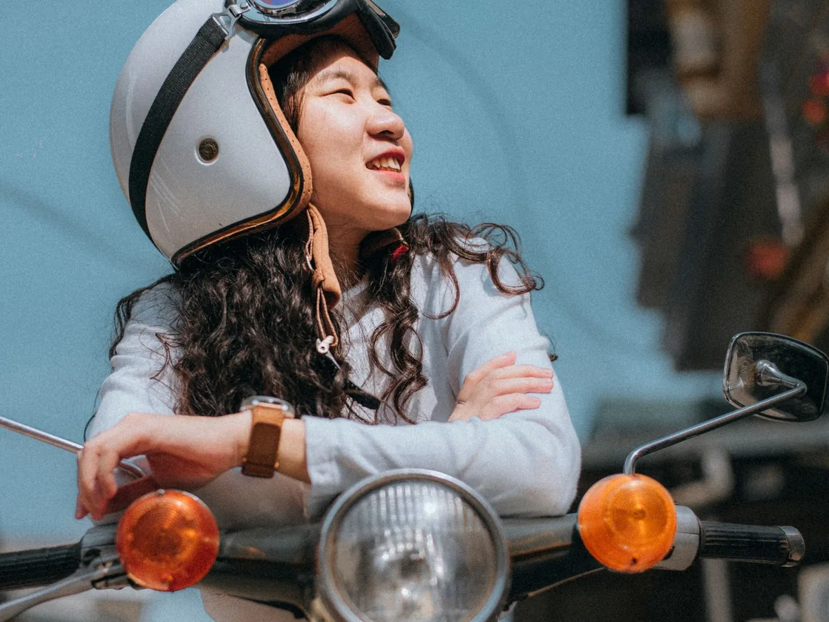 Jeune conducteur souriant sur un scooter 50cc avec casque